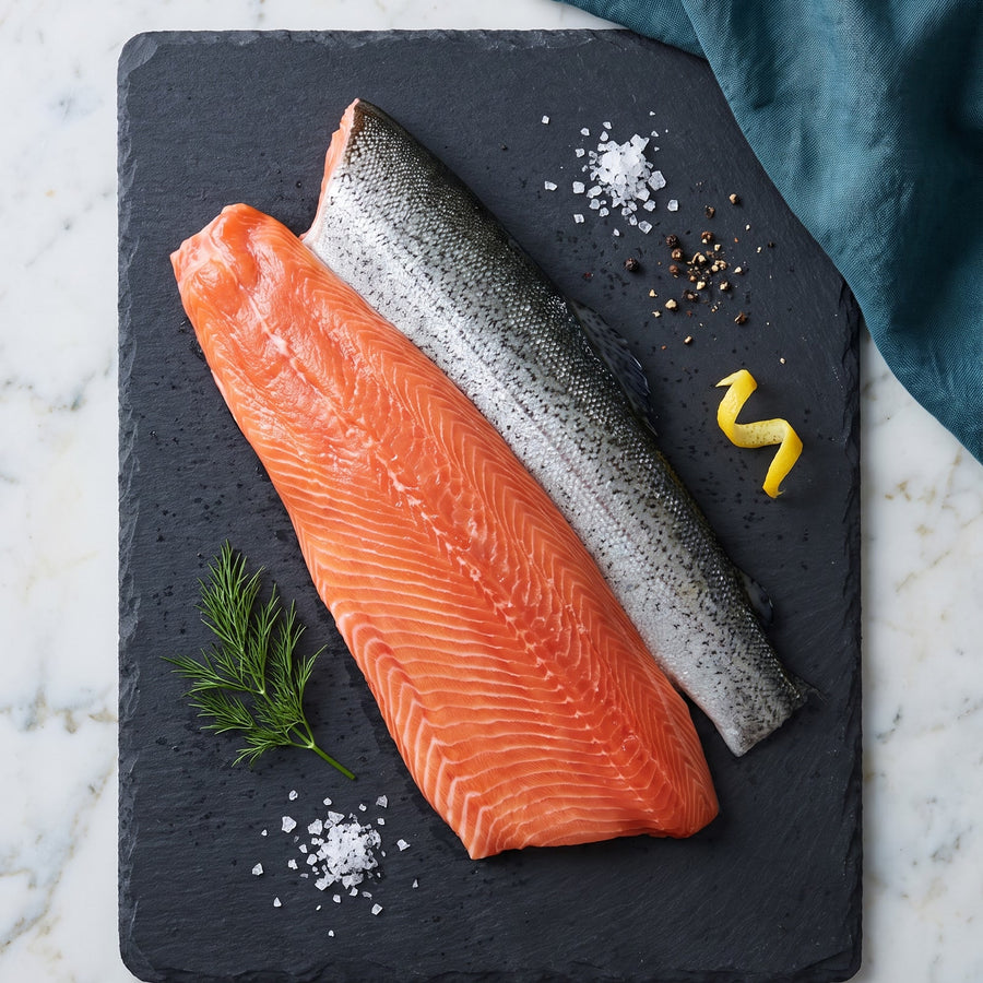 Hel side av regnbueørret med skinn på skiferplate - D-trim ørretfilet fra Hofseth, frossen