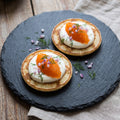 Løyrom servert på blini med crème fraîche, rødløk og dill